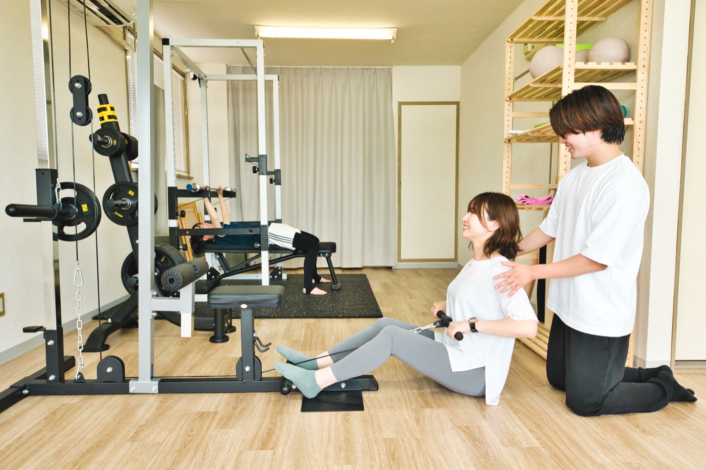 運動初心者の女性にトレーナーが姿勢を案内するLIFESHIFTの利用風景