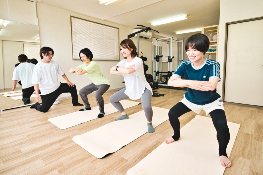 LIFESHIFTで女性3名がトレーナーのサポートを受けながら少人数トレーニングに取り組む様子