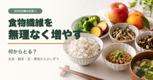 麦ごはん、納豆、ブロッコリー、きのこ、海藻、さつまいも、りんご、みかんを並べた食卓と、食物繊維を無理なく増やすという日本語タイトル